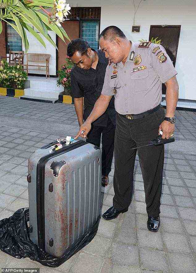 Police inspect a blooded suitcase containing von Wiese Mack's broken corpse in August 2014
