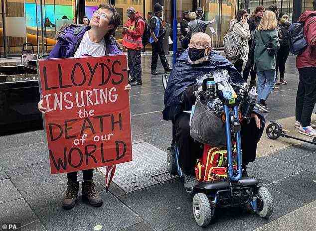 Ein Demonstrant hält am Freitag vor Lloyds of London ein Schild mit der Aufschrift 