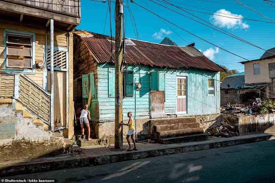 In den farbenfrohen Straßen von Soufrière stehen Holzhäuser in karibischen Pastelltönen