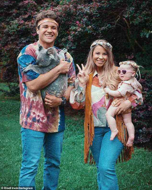Happy hippie Halloween: Bindi Irwin decided to step back in time for the spookfest. The 23-year old wildlife warrior and her husband Chandler decided to embrace their inner hippie for the occasion. Sharing their family outing to Instagram, Bindi is seen throwing up the peace sign as she holds daughter Grace Warrior, who also got in on the action