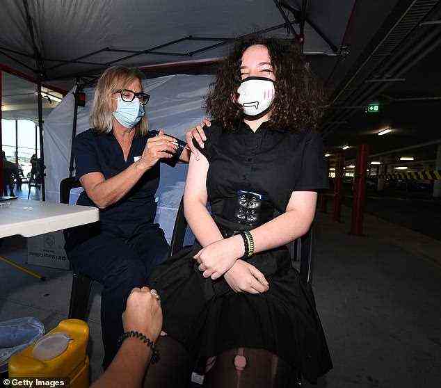 Die 13-jährige Emily Connor erhält am 16. Oktober in einem Baumarkt von Bunnings in Brisbane einen Covid-19-Impfstoff