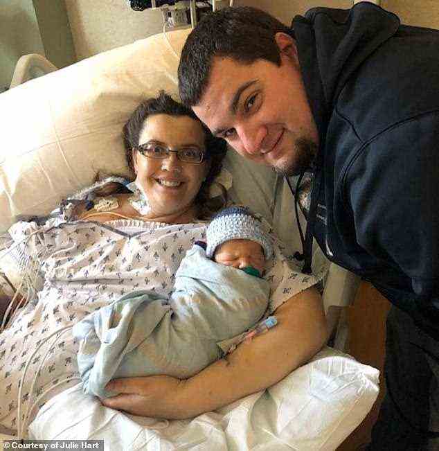 Julie Janzen, 37, aus Taylor, Wisconsin, musste sich einem Notfallkaiserschnitt und einer Herzoperation unterziehen, nachdem die Ärzte festgestellt hatten, dass sie einen Riss in der Aorta hatte.  Im Bild: Janzen mit ihrem Ehemann Kyle (rechts) und ihrem Sohn Logan kurz nach seiner Geburt
