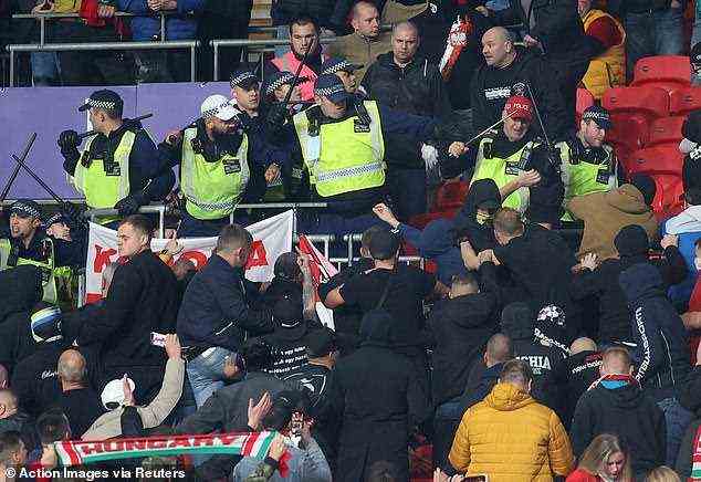 Bereitschaftspolizei versucht, ungarische Fans zurückzudrängen, die im Wembley-Stadion über Sitze geklettert sind
