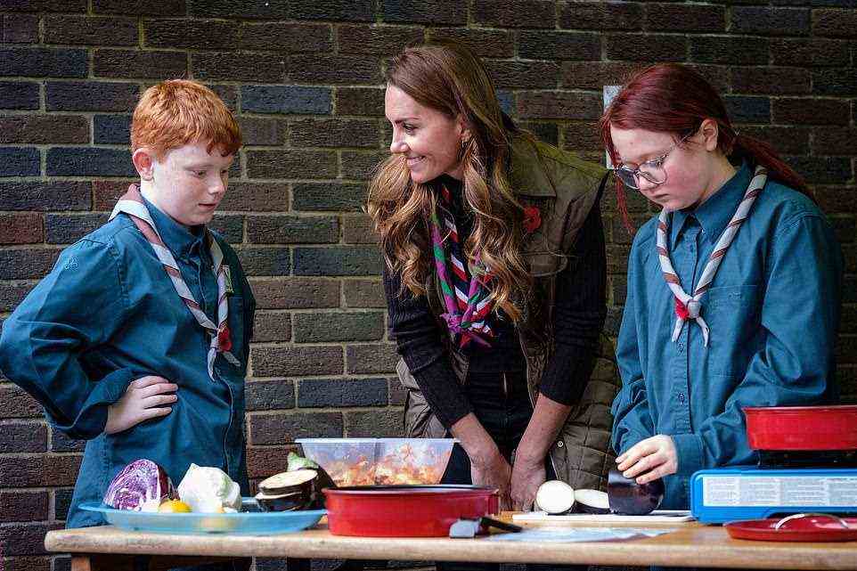 Meanwhile Kate appeared in high spirits as she leant down to speak with Scouts who were serving up food and practicing their cooking skills