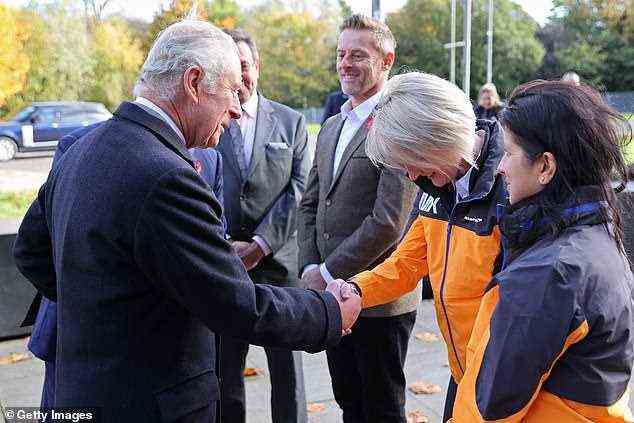 Prinz Charles schüttelt Emma Gilmours Hand, während Ingenieurin Leena Gade zuschaut