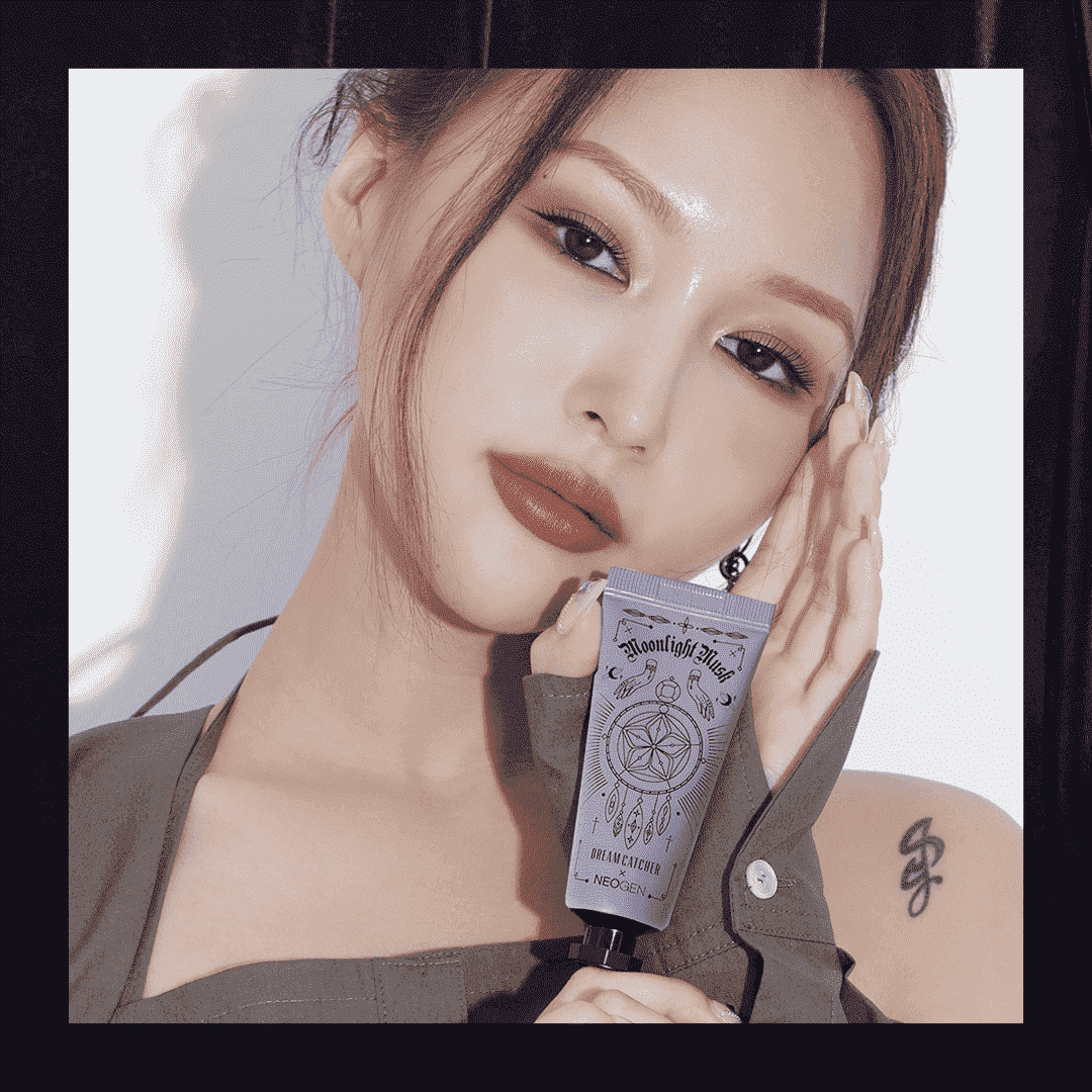 Ein Studiofoto von Dreamcatcher-Mitglied Siyeon, das ihre Neogen-Handcreme auf weißem Hintergrund mit schwarzem Rand hält