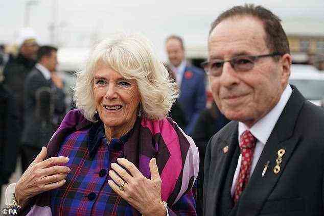 The royal looked typically smart in an electric blue, black and red plaid jacket that had a velvet trim around the collar and matching buttons as she spoke to creator, Peter James (pictured)