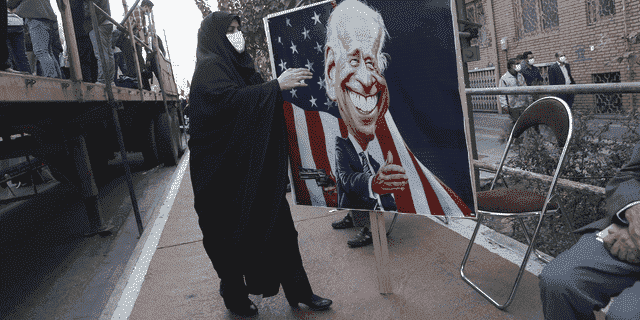 Ein Demonstrant trägt am Donnerstag im iranischen Teheran ein Transparent mit einer Karikatur des US-Präsidenten Joe Biden. 
