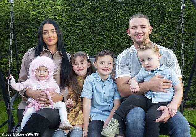 Das Paar ist zu Hause mit Baby Millie und ihren Kindern Ava (7), Zachary (5) und Tommy . abgebildet
