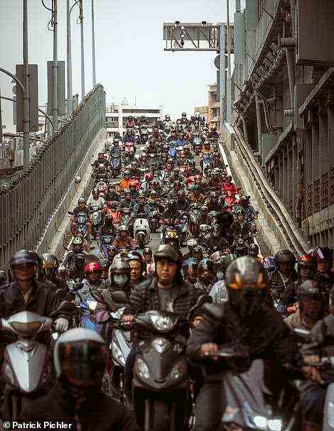 Behold, Minquan West Road in Taipei's Datong District. The road is famed for its 'moped waterfall', which sees the highway exit fill with mopeds at rush hour. Schels and Pichler write: ' More than three-quarters of the vehicles in the city are motorcycles and scooters, which make for quick and nimble travel, with no parking problems at all.' The book reveals that Taiwan is the country that has the most mopeds per capita