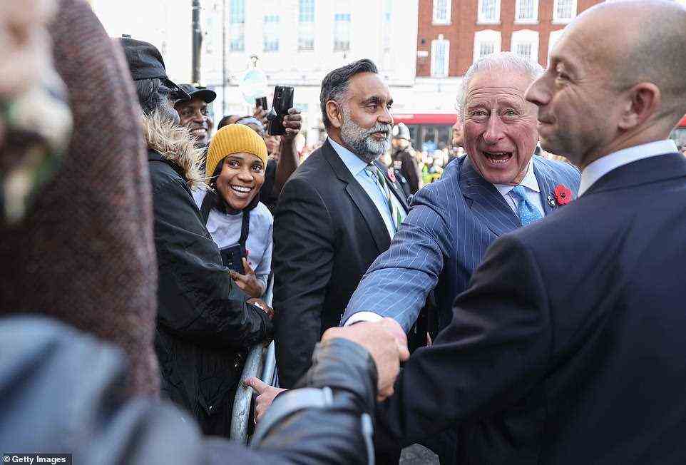 Prince Charles shakes hands with well-wishers as he leaves the NatWest bank branch in Brixton, South London, this morning