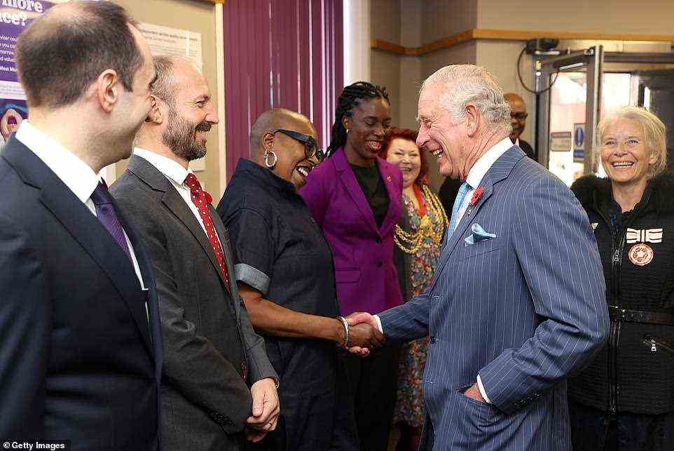 Charles is seen beaming today as he shakes hands with independent health and social care consultant Jacqui Dyer MBE