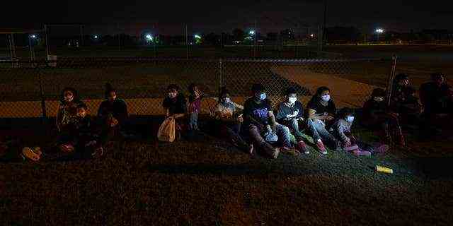 Migranten warten an einem Aufnahmebereich, nachdem sie sich am späten Dienstag, 11.  Die US-Regierung meldet weiterhin eine große Zahl von Migranten, die die amerikanisch-mexikanische Grenze überqueren, wobei die Zahl der erwachsenen Grenzgänger zunimmt.  Aber trotz des Wetterumschwungs im Rio Grande Valley mit heißeren Tagen und Nächten kommen immer noch Familien und unbegleitete Kinder in dramatischer Zahl an.  (AP Foto/Gregory Bull)