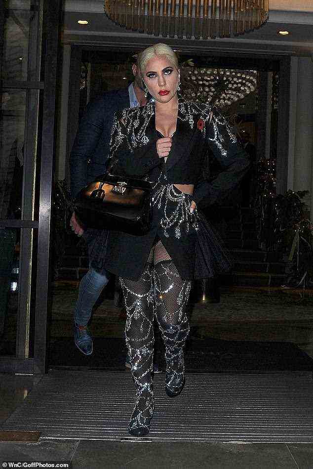 Exzentrisch: Gaga verblüffte in dem auffälligen Outfit und fügte Netzstrümpfe und einen Hauch roten Lippenstifts hinzu, um den dramatischen Look zu vervollständigen