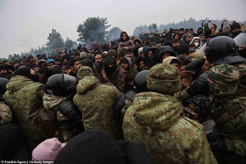 Belarus denies engineering the crisis and has warned that armed groups in Ukraine are trying to give weapons to the migrants to spark a conflict (pictured, Belarusian troops marshal thousands of migrants near the border)