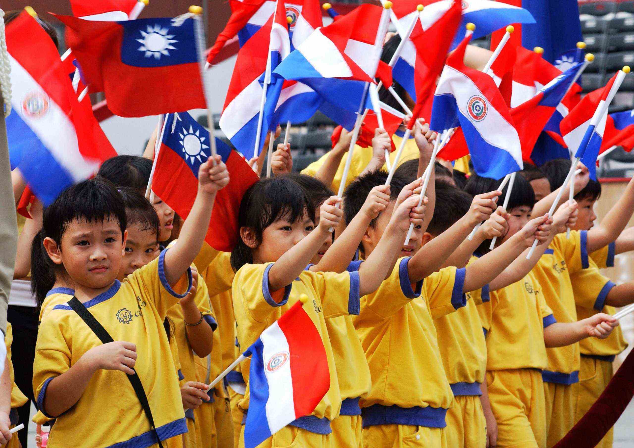 Kinder schwenken die Nationalflaggen von Paraguay