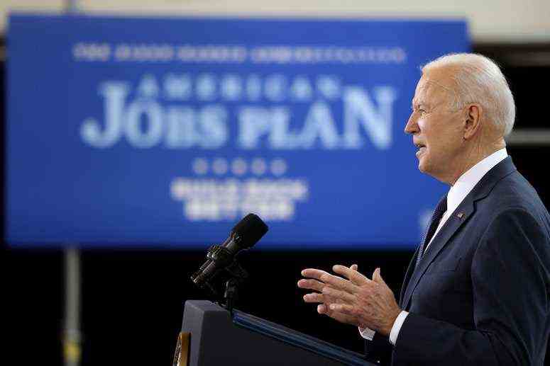 Präsident Joe Biden spricht auf einem Podium vor einem Schild mit der Aufschrift "Amerikanischer Jobplan"