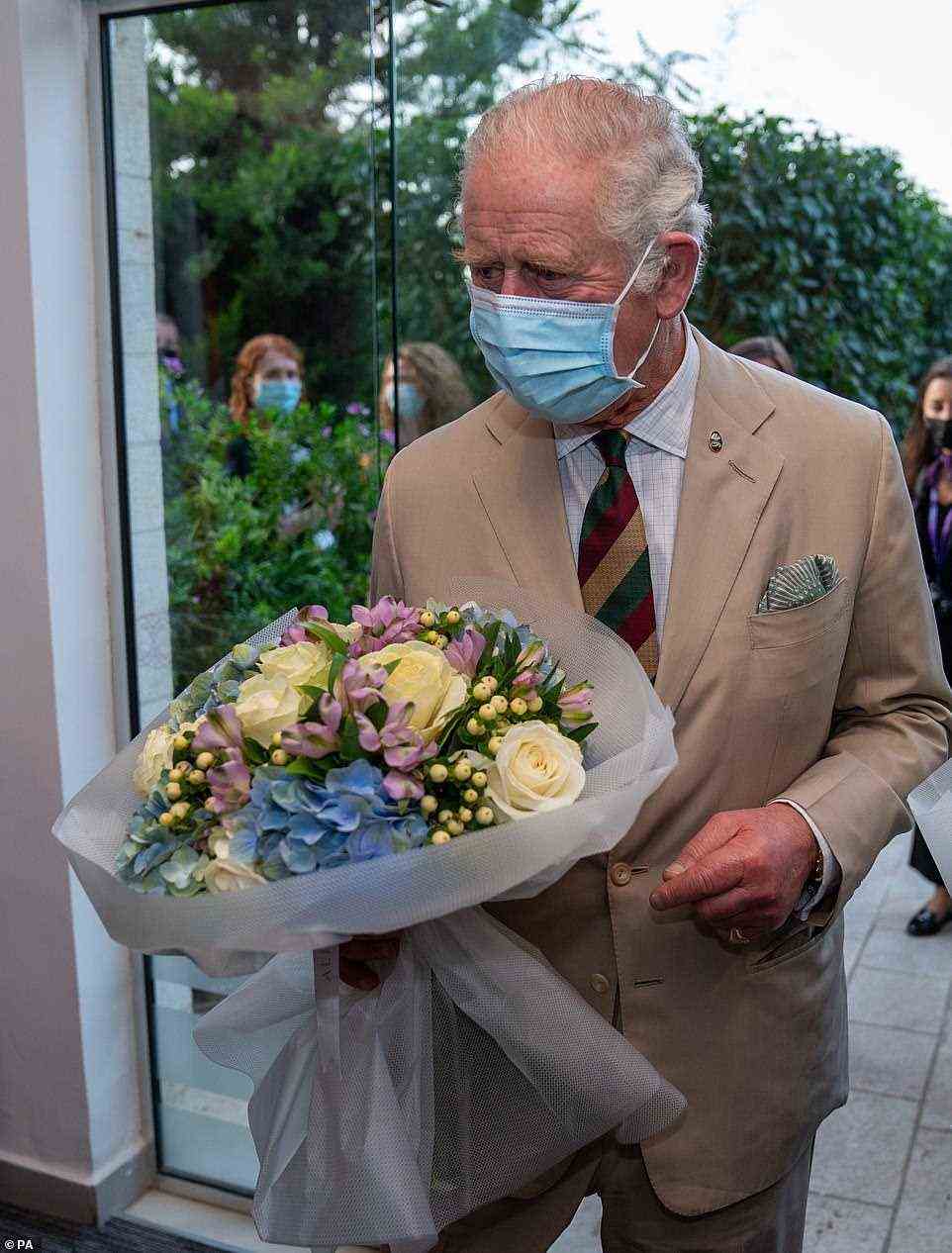 The Prince carries a floral bouquet as he arrives at the community centre in the capital; the project supports refugees starting a fresh life in Jordan after fleeing nearby countries