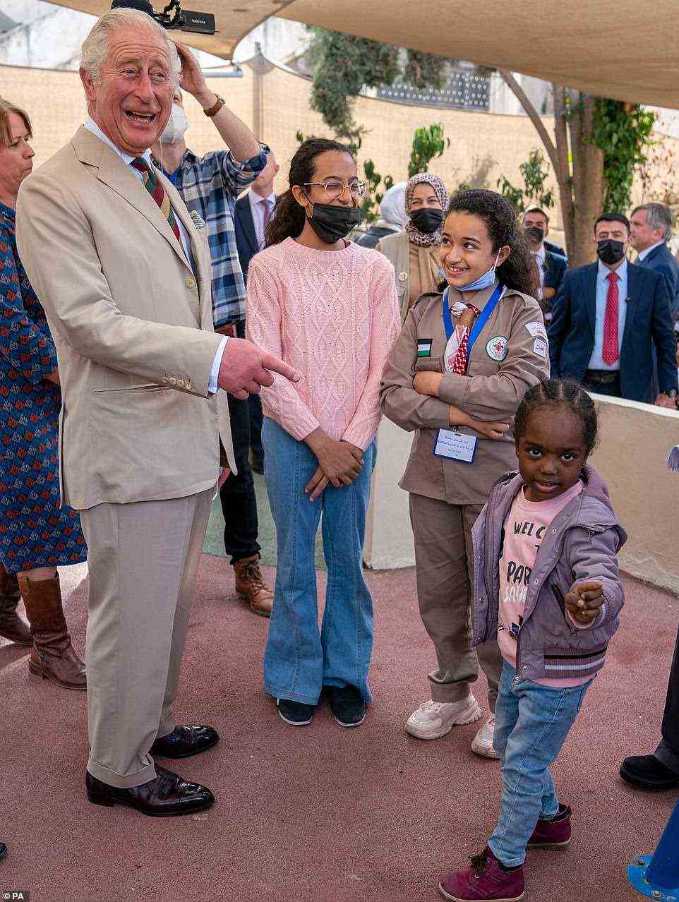 The royal was on jovial form this afternoon in Jordan as he met four-year-old Salapelo while visiting the community centre