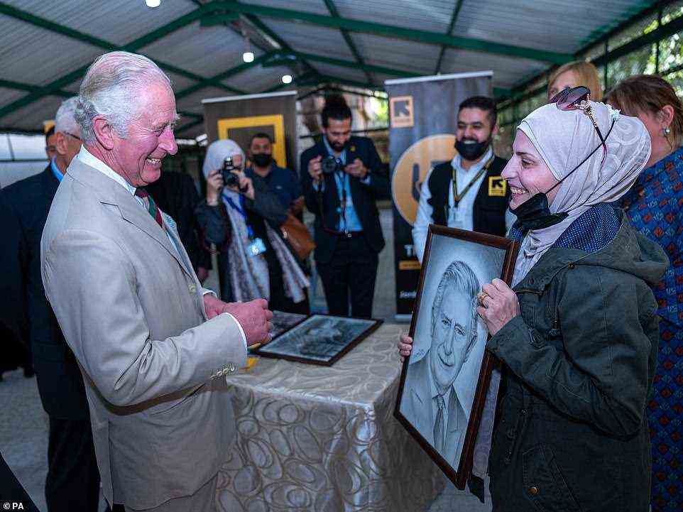 You've got one's likeness! The Prince of Wales admires the portrait given to him by Syrian refugee artist Faihaa