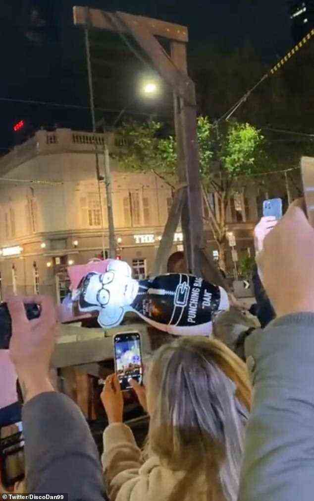 Anti-Impfstoff-Demonstranten rollten am Montagabend einen hölzernen Galgen zu den Stufen des Parlamentsgebäudes von Melbourne, um während einer wilden Kundgebung ein Bildnis von Dan Andrews aufzuhängen