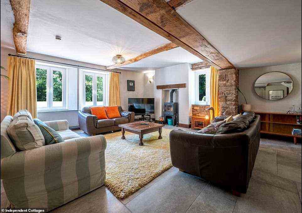 Das gemütliche Wohnzimmer im Haus, wo die Gäste es sich auf großen Sofas am Holzofen gemütlich machen können
