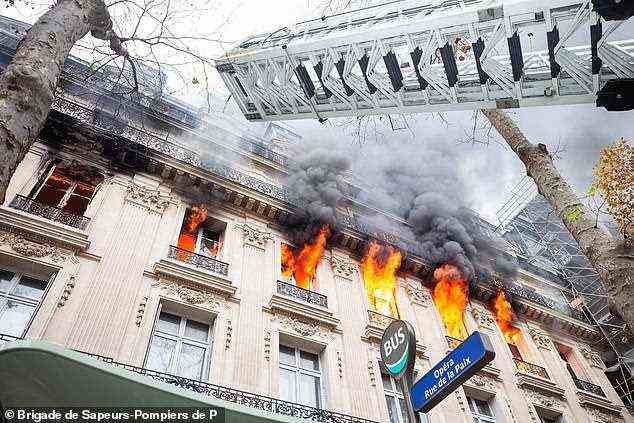 Flammen sind im Fenster des Pariser Gebäudes zu sehen, das heute Morgen Feuer gefangen hat