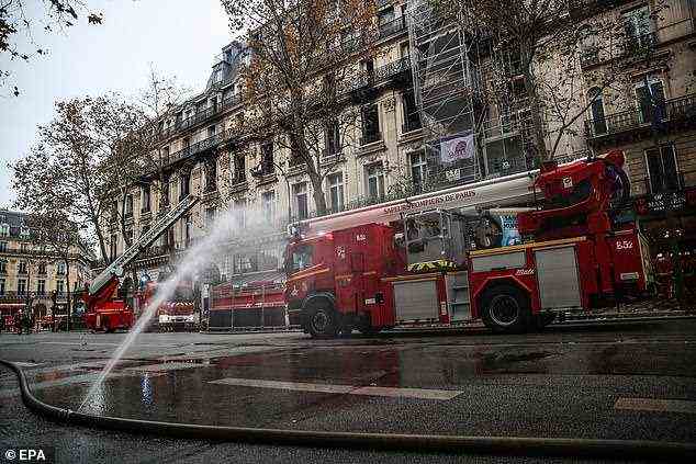 Feuerwehrautos sind an der Szene abgebildet, an der das Feuer in einer ikonischen Pariser Straße ausgebrochen ist