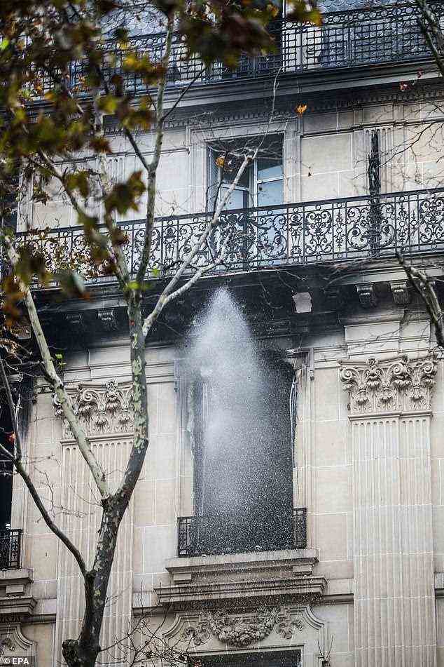Wasserspritzer verschlingen die Fenster des Gebäudes, das unten Büros, Wohnungen und Geschäfte beherbergt
