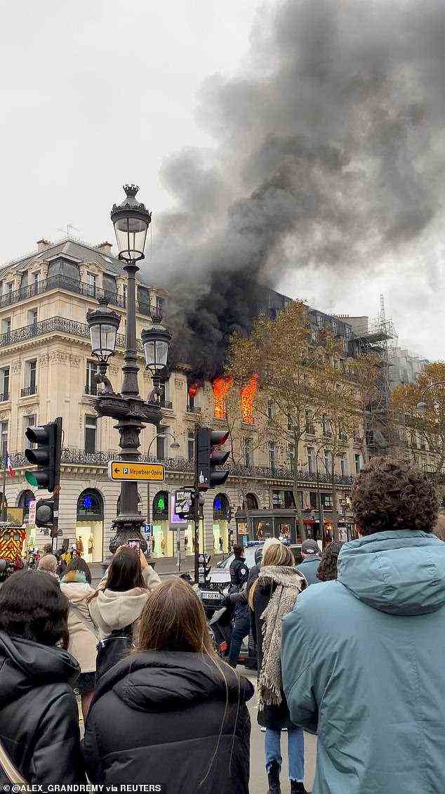 Schaulustige in Paris beobachten, wie Flammen das Gebäude erfassen