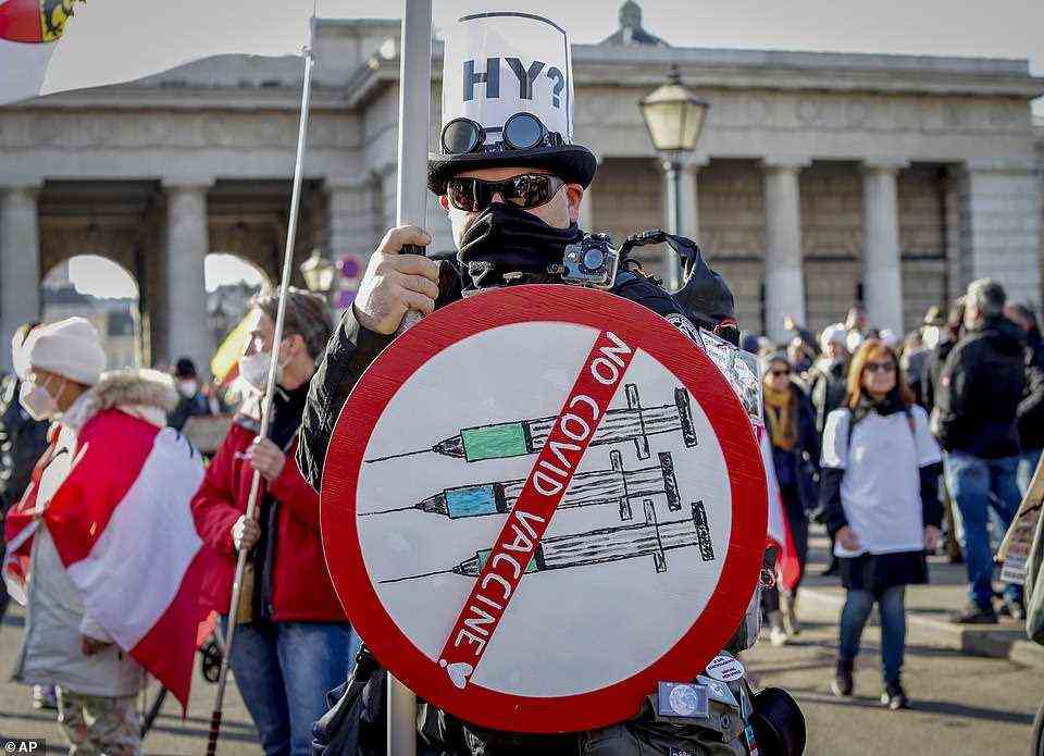 A protester, with a sign reading 'No Covid vaccine', joins thousands of people demonstrating in Vienna against Covid rules