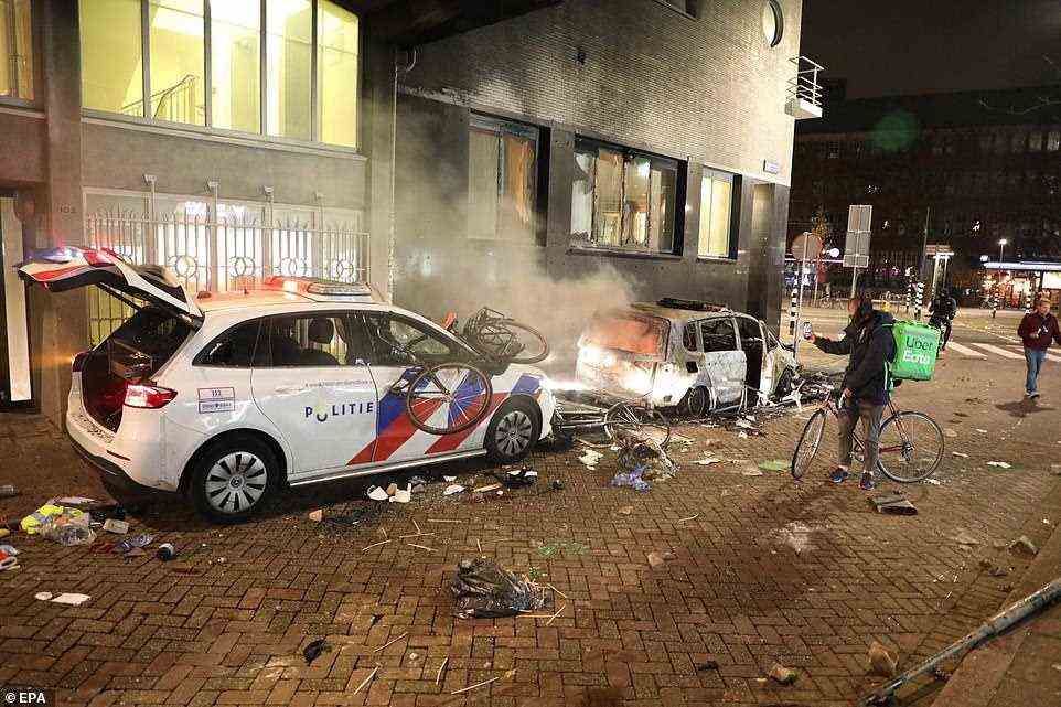Damaged police cars and bikes littered the streets after an anti-lockdown protest turned into the riots in Rotterdam on Friday