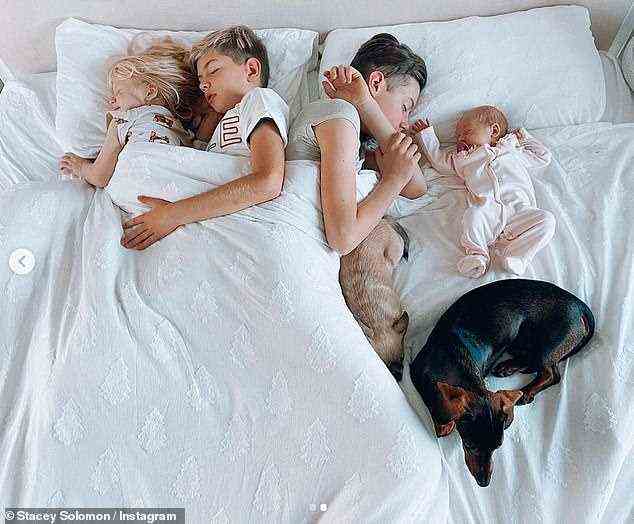 Süß: Die Kinder der Moderatorin sahen friedlich aus, als sie mit ihren beiden Hunden am Fußende des Bettes nebeneinander ein Nickerchen machten