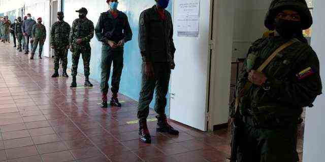 Soldaten stellen sich während der Regionalwahlen in einem Wahllokal in Caracas, Venezuela, am Sonntag, den 21. November 2021, zur Abstimmung auf. Die Venezolaner gehen zu den Urnen, um Gouverneure der Bundesstaaten und andere lokale Beamte zu wählen.  (AP-Foto/Ariana Cubillos)