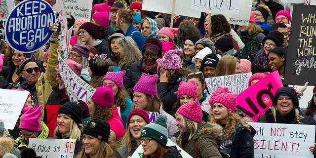 Demonstranten halten ihre Transparente hoch, während sie während des Frauenmarsches in Washington am Samstag, den 19. Januar 2019, auf der Pennsylvania Avenue marschieren. (AP Photo/Jose Luis Magana)
