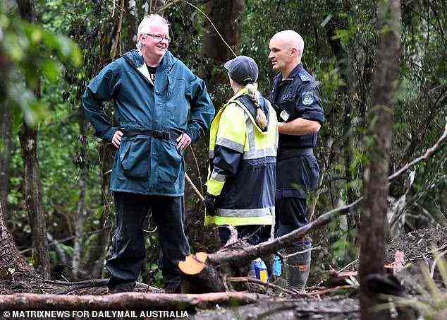 Der Hydrologe Professor Jon Olley (links) unterhält sich mit der Polizei, während die regennasse Suche fortgesetzt wird