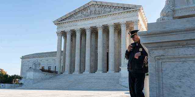 Ein Polizist bewacht während einer Demonstration von Opfern von Waffengewalt vor dem Obersten Gerichtshof, als am 3. November 2021 in Washington, DC, in einem wichtigen Fall zu Waffenrechten die Auseinandersetzungen beginnen  