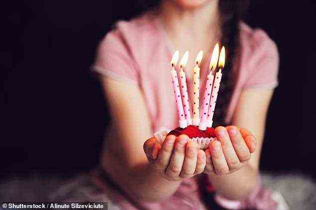 Die Haare des Mädchens fingen Feuer, als sie sich vorbeugte, um die Kerzen auf ihrem Geburtstagskuchen auszublasen (stockfoto)