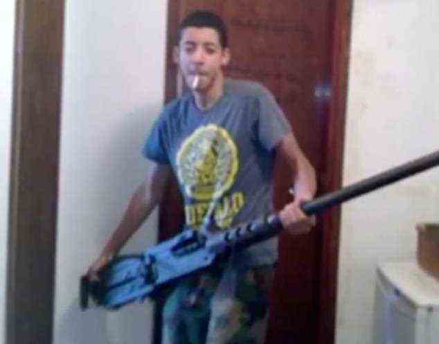An image shown to the Manchester Arena inquiry shows suicide bomber Salman Abedi, 22, carrying a huge machine gun while smoking a cigarette