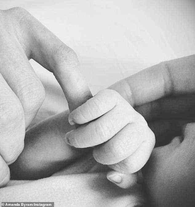 “Überglücklich”: Der Star postete einen Schnappschuss der winzigen Hand ihres Babys, während sie sich und den langen Weg ihres Mannes Julian, Eltern zu werden, detailliert beschreibt