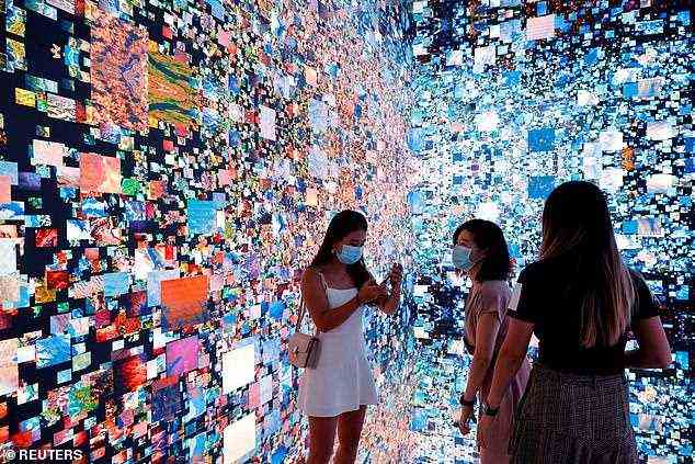 Hongkong: Besucher werden vor einer immersiven Kunstinstallation mit dem Titel "Maschinenhalluzinationen Space: Metaverse" des Medienkünstlers Refik Anadol, der in NFT umgewandelt und online bei Sotheby's auf der Digital Art Fair in Hongkong versteigert wird