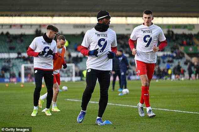 Wyke's Wigan team-mates show their support for him during their pre-match warm-up before their League One clash with Plymouth Argyle last month