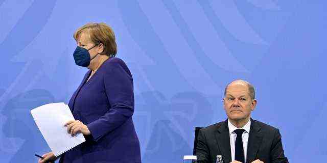 Bundeskanzlerin Angela Merkel (links) und Finanzminister Olaf Scholz kommen zu einer Pressekonferenz nach einem Treffen mit den Regierungschefs der deutschen Bundesländer im Kanzleramt in Berlin, Donnerstag, 2. Dezember 2021. (John Macdougall/Pool Photo via AP)