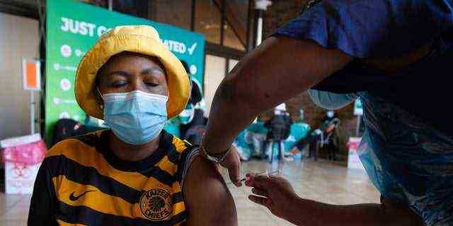 Eine Frau erhält am Mittwoch, den 2. Dezember 2021 in einer Einrichtung in Soweto, Südafrika, einen COVID-19-Impfstoff. Südafrika hat seine Impfkampagne beschleunigt, indem es an Pop-up-Sites in Einkaufszentren und Verkehrsknotenpunkten Impfungen verabreicht hat, um den rapiden Anstieg zu bekämpfen neue Fälle von COVID-19.  (AP-Foto/Denis Farrell)