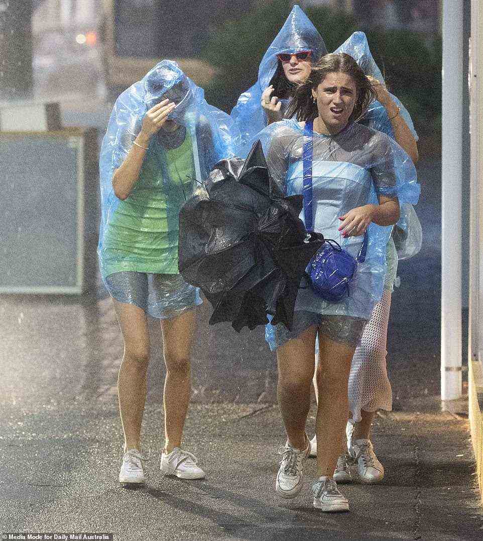 Andere hatten das Glück, mit Regenschirmen und sogar Regenmänteln (im Bild) bewaffnet zu sein, als der Regen am Samstag in Byron Bay peitschte