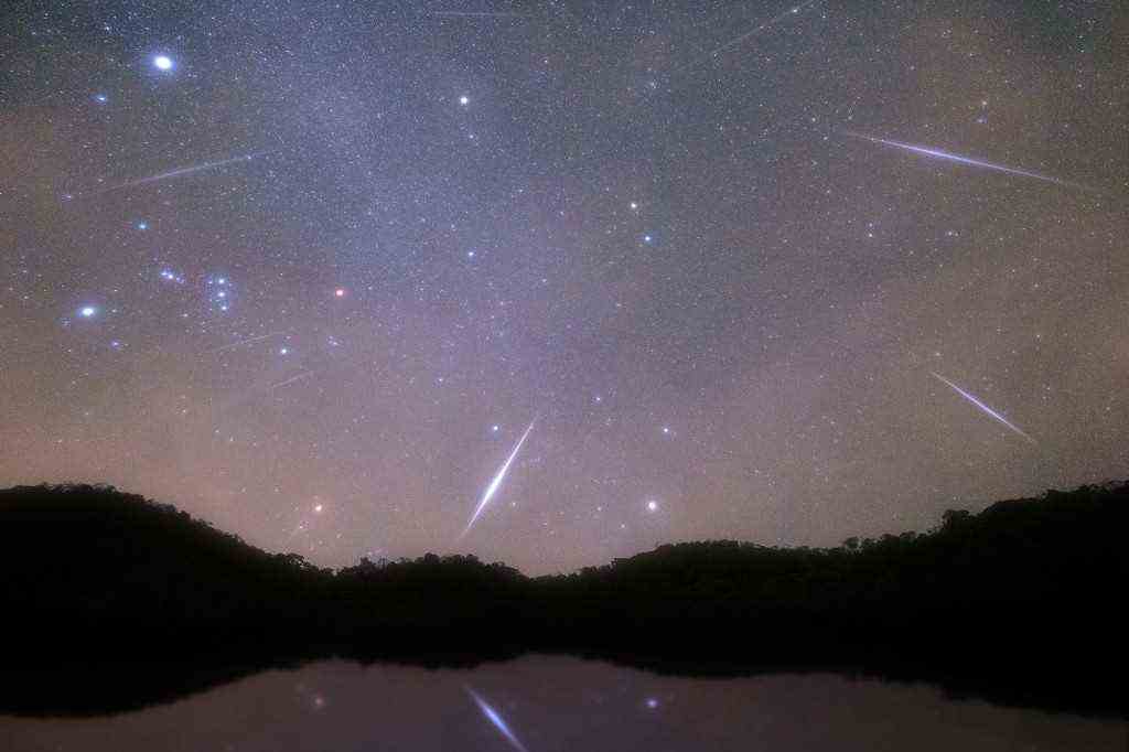 Geminid Meteor am Nachthimmel am See. 