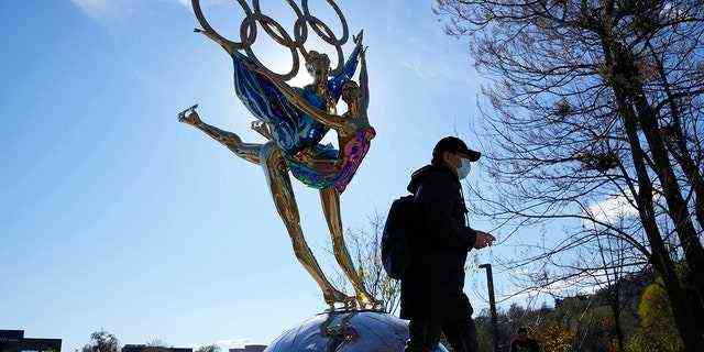 Ein Besucher des Shougang-Parks geht am Dienstag, 9. November 2021, an einer Skulptur für die Olympischen Winterspiele in Peking in Peking, China, vorbei. 