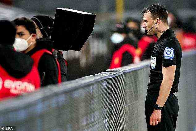 Zwayer überprüft den VAR-Monitor am Spielfeldrand, bevor er den Bayern ihren Elfmeter zuspricht