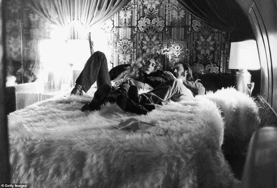 Flying high: Robert Plant and Richard Cole recline on a fur-covered bed ahead of a concert in New York in 1973. Cole was eventually fired in 1980 after succumbing to a heroin addiction