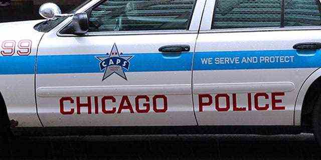 Chicago, Vereinigte Staaten - 26. Juni 2013: Leute gehen am 26. Juni 2013 in Chicago am Polizeiauto vorbei.  Das Chicago Police Department ist eine der ältesten Polizeikräfte der Welt und stammt aus dem Jahr 1837.